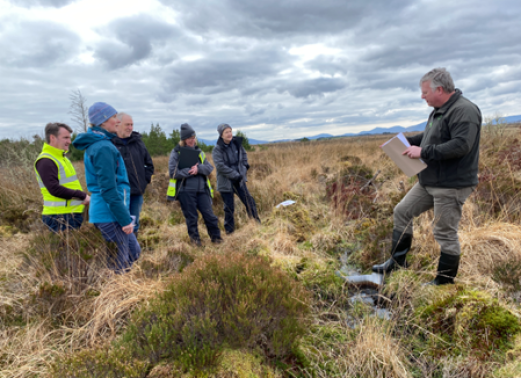 a group of people standing on a peat bog