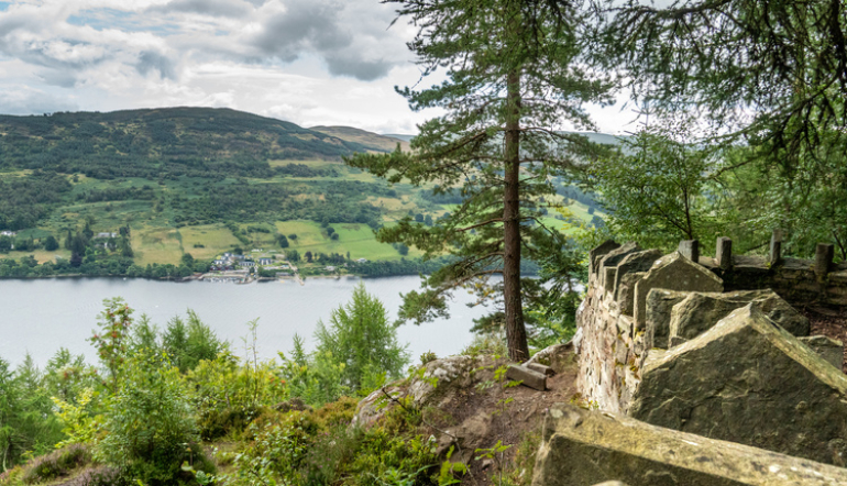 A stoned wall protecting a viewpoint looking over the river Tay with a village on the other side of the river