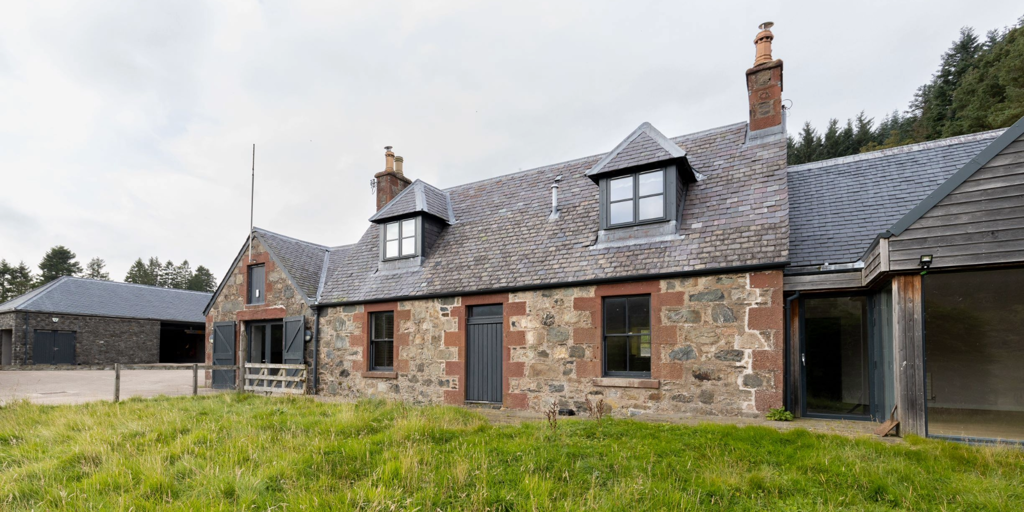 Image of a cottage and outbuildings.