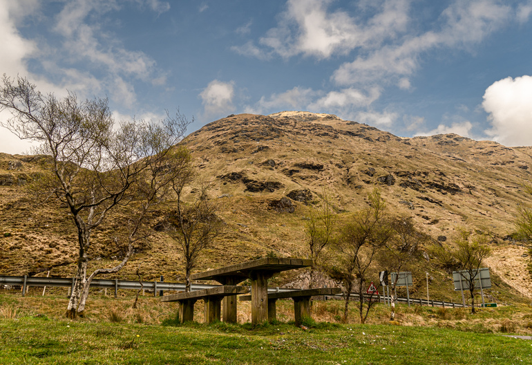 A picnic table next to a hill 