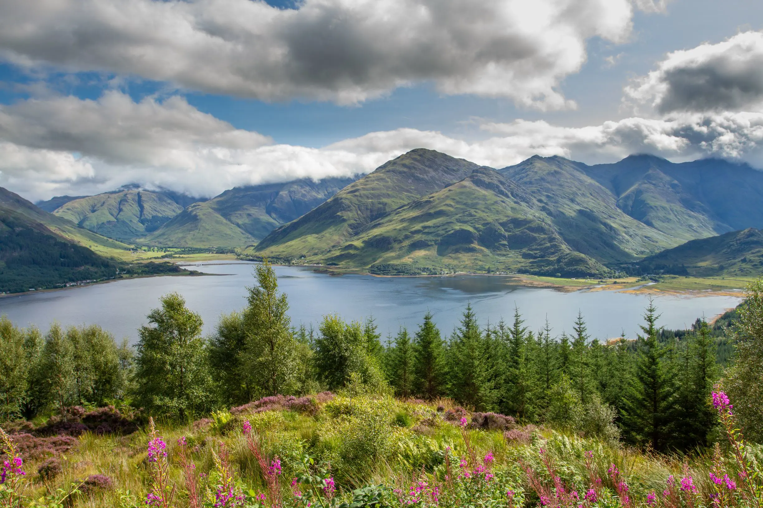 A large loch surrounded by grass-covered mountains at Ratagan