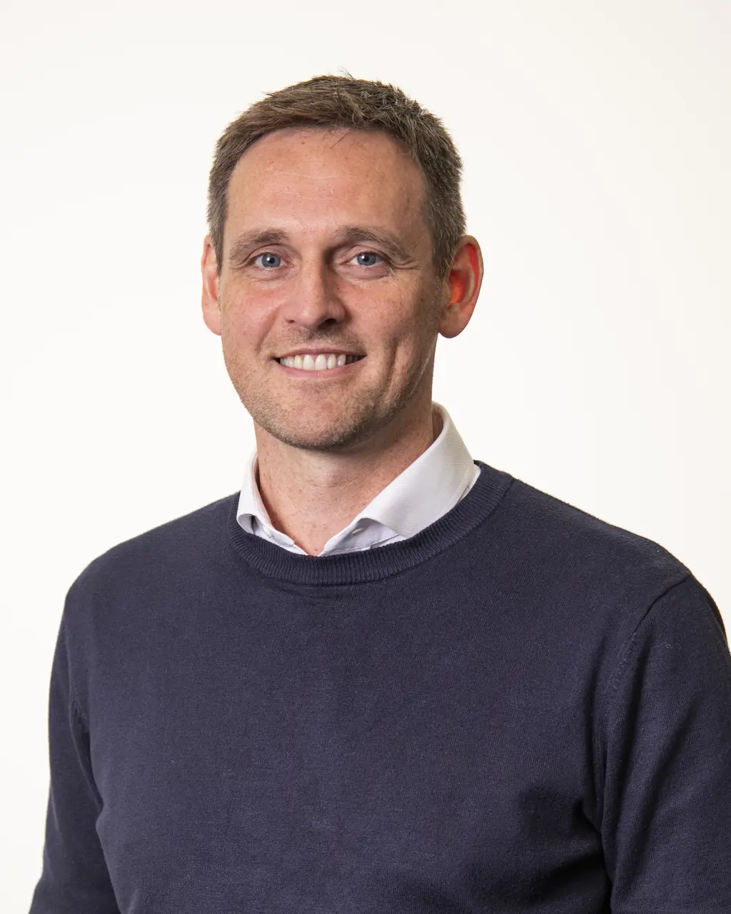 Headshot of David Leven smiling against a white background.