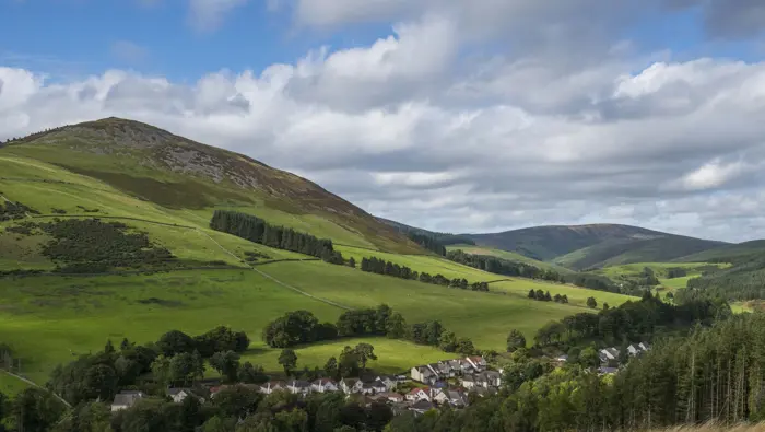Rolling hills with fields, houses and forestry.