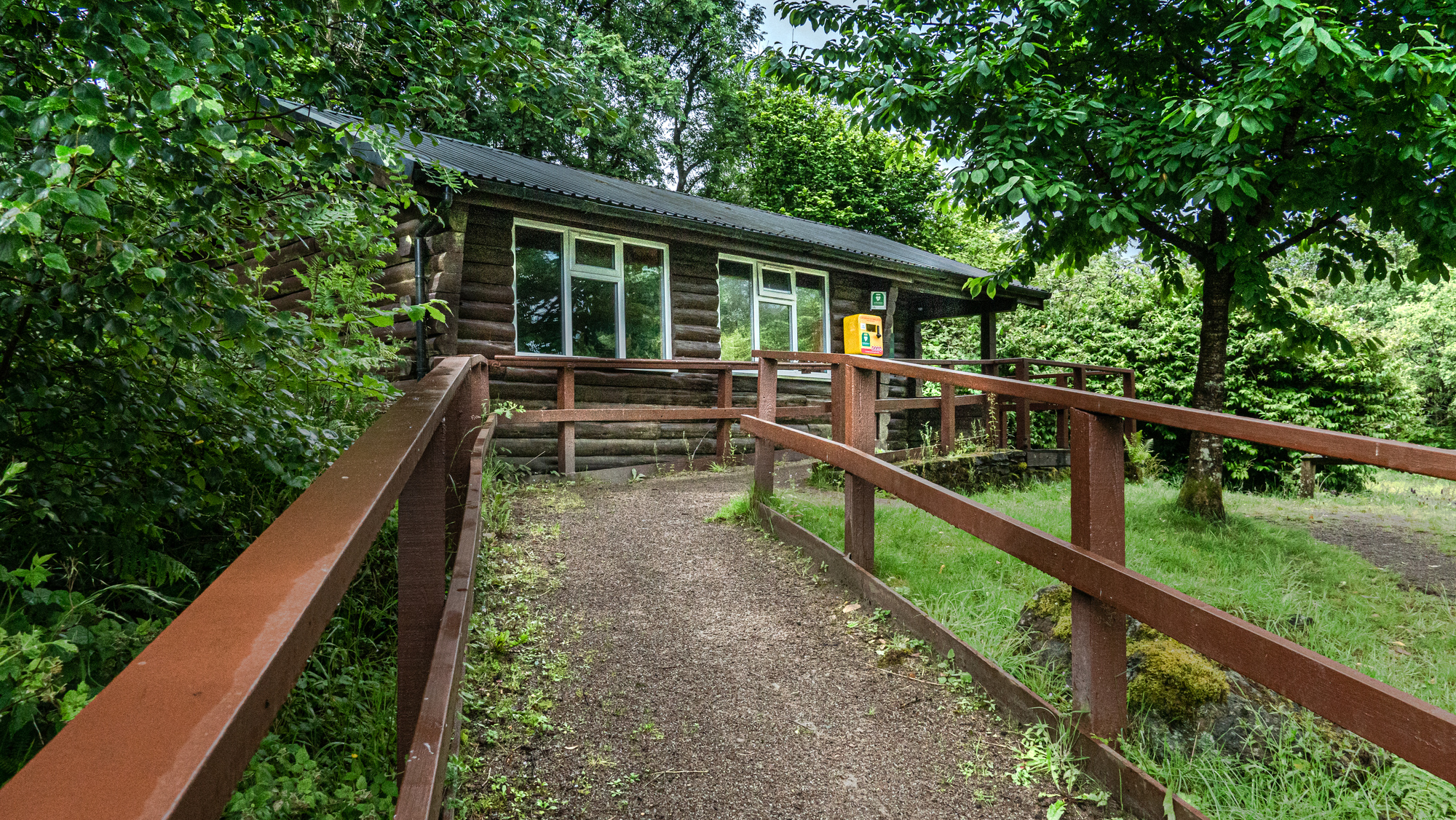 An accessible ramp up towards a log cabin in the trees