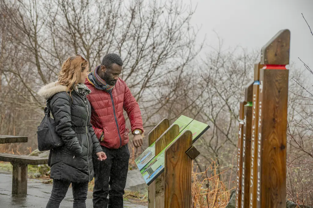 Couple looking at interpretation panels/signage at the trailheads at The Lodge Forest Visitor Centre.