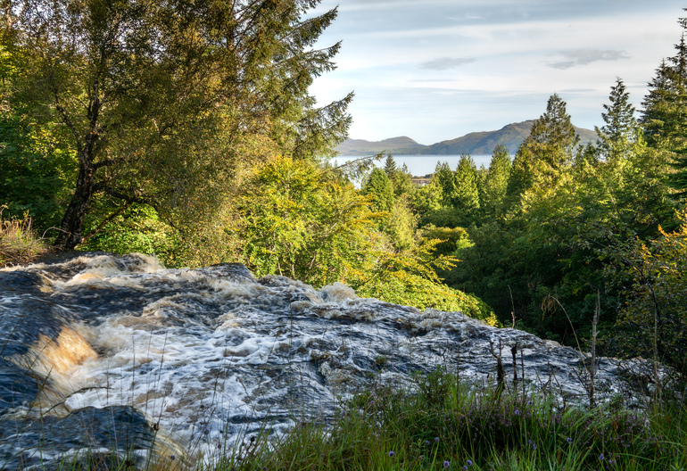 he top of a waterfall overlooking the sea and forest
