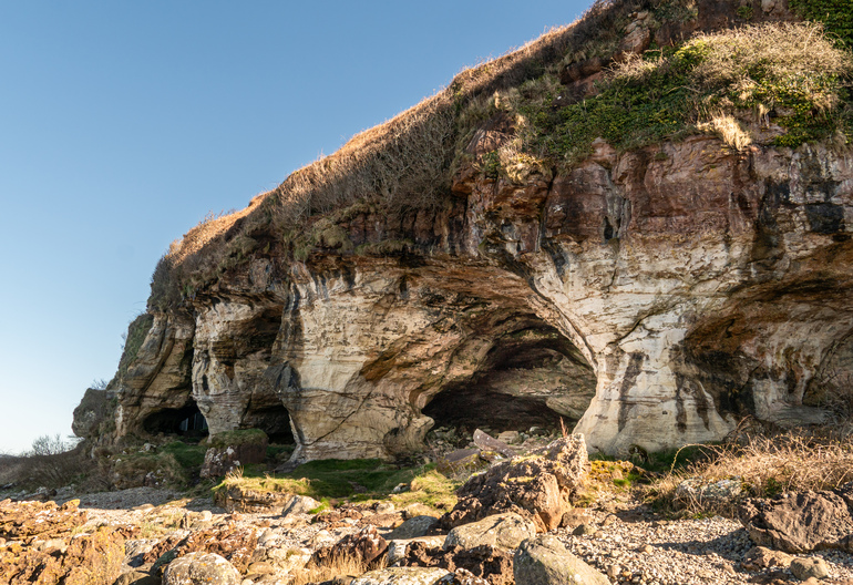 A rock cliff with caves