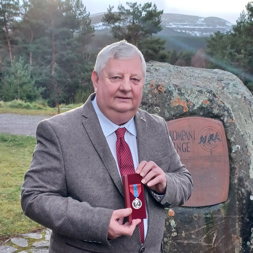 Allan MacDougall with medal next to Kompani Linge memorial stone.