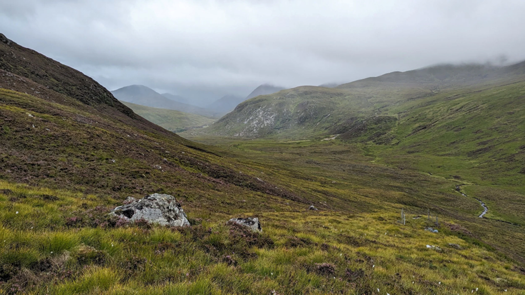 A view down a glen between misty mountains 
